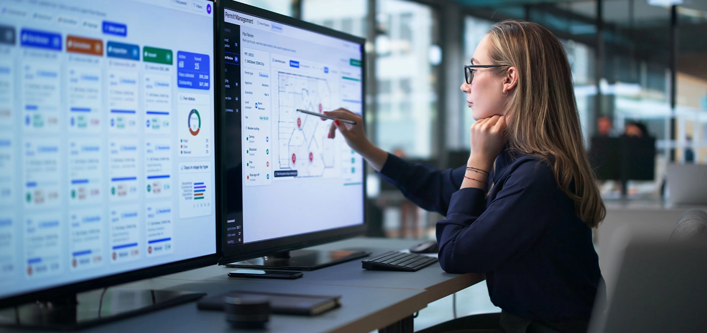 Profesional analizando datos empresariales en tiempo real desde paneles de control digitales en una oficina moderna, mejorando la eficiencia y la toma de decisiones.